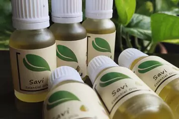 savi essential oil bottles arranged on a wooden table with plants in background.