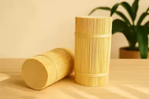 stacks of bamboo sticks placed on a wooden table with a clean and minimal background.