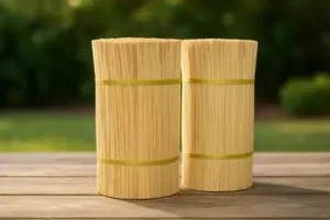 two stacks of bamboo sticks standing upright on a wooden table in a garden.