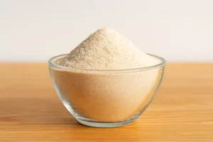 Psyllium Husk psyllium husk powder in a glass bowl placed on a table.